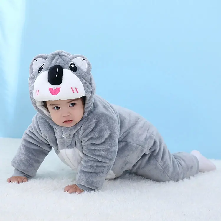 Dette billede viser et nuttet og blødt koala-kostume til børn, udført i gråt og hvidt plys. Dragten har en hætte med et detaljeret koala-ansigt, store plyssede ører og en praktisk lynlås foran, hvilket gør den ideel til både leg og fastelavn.