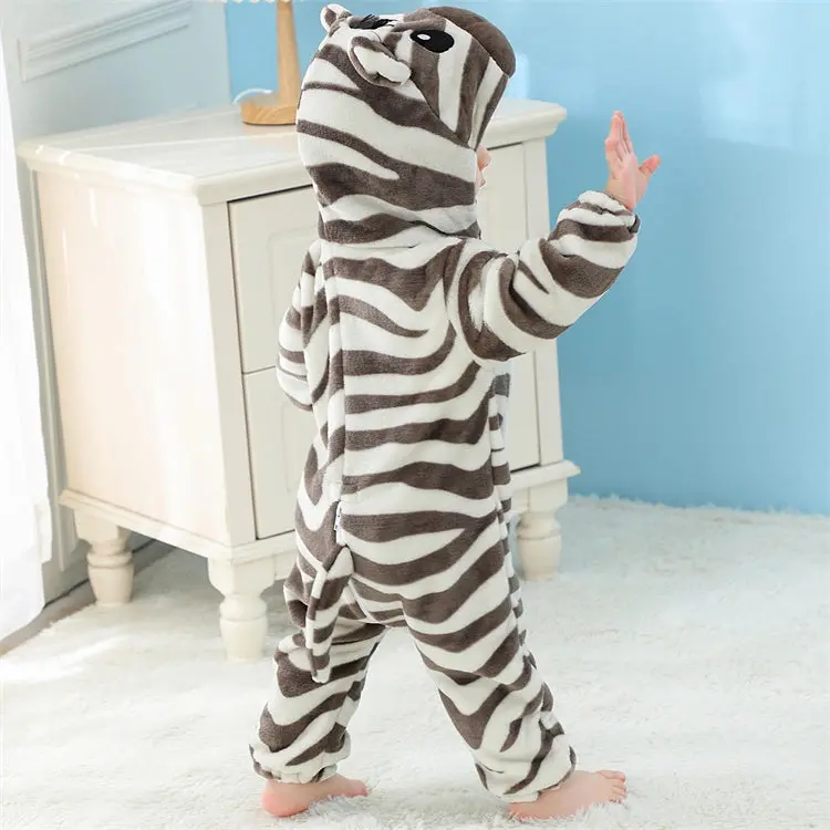 Et blødt og nuttet zebra-kostume til børn i hvidt og sort stribet flannelmateriale. Dragten har en hætte med ører, en lille manke og et sødt ansigt, hvilket gør den ideel til både udklædning, leg og fastelavn.