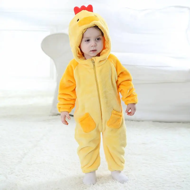 Dette billede viser et nuttet og blødt gult kyllingekostume til børn. Dragten er lavet af vamset flannel med en hvid mave, vinger på ærmerne og en hætte, der har et sødt kyllingeansigt med et orange næb og øjne.